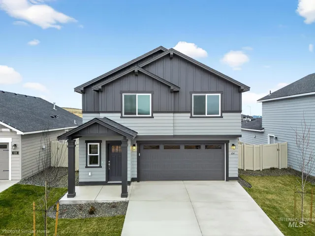 View of front of house featuring board and batten siding, an attached garage, and driveway