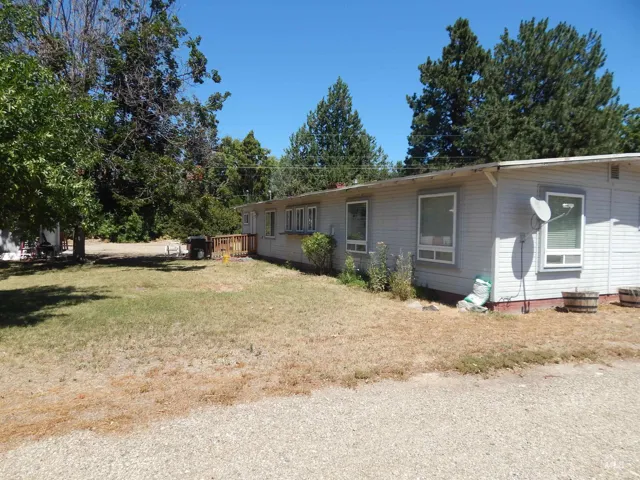 View of side of property with a yard and a wooden deck
