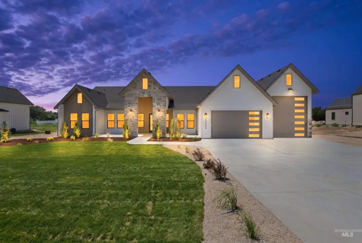 Modern exterior featuring white siding, stone accents, and dark gabled roofing