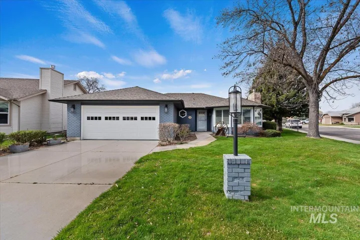 Single story home with a garage, brick siding, concrete driveway, and a front yard