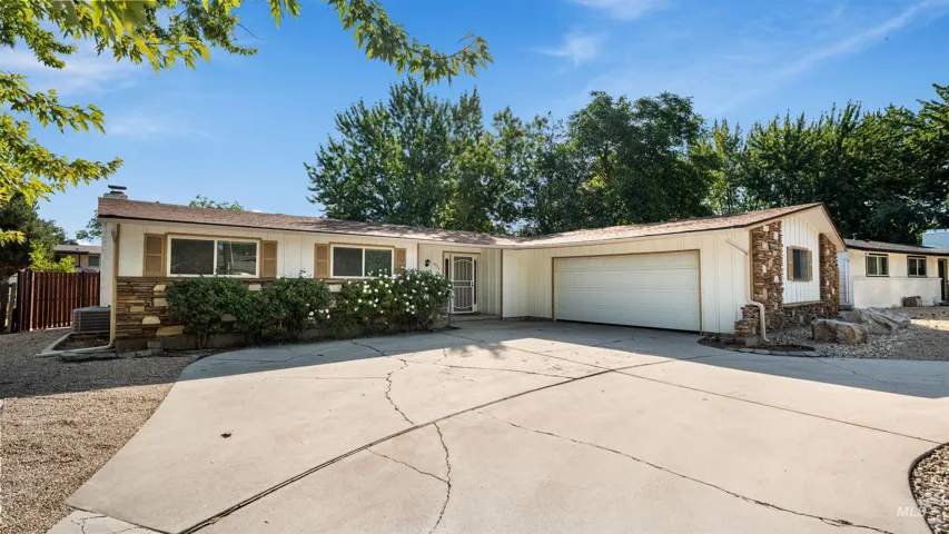 Single-story exterior with a two-car garage, stone accents, and a concrete driveway