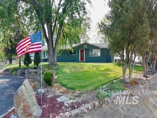 Ranch-style exterior with a deep teal facade and a contrasting red front door