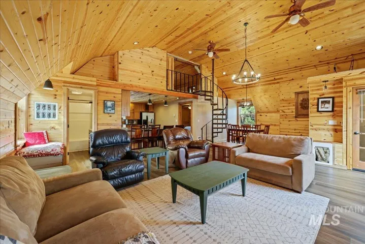 Spacious living area featuring extensive wood-finish paneling, a distinctive spiral staircase, and an open-concept design
