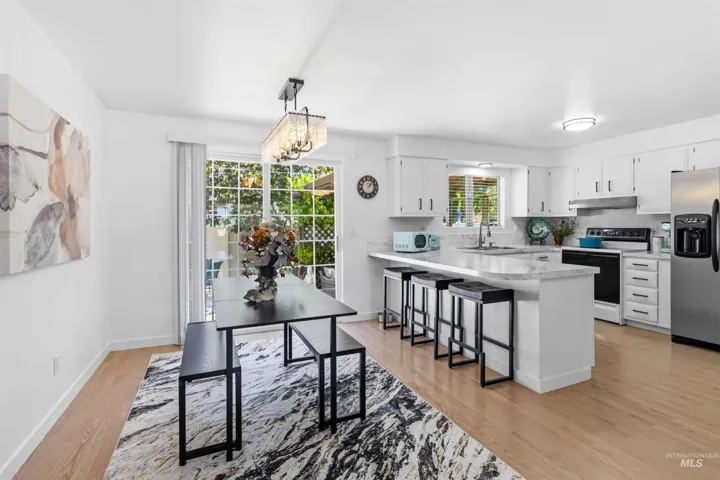 Bright kitchen and dining area featuring light wood-finish flooring