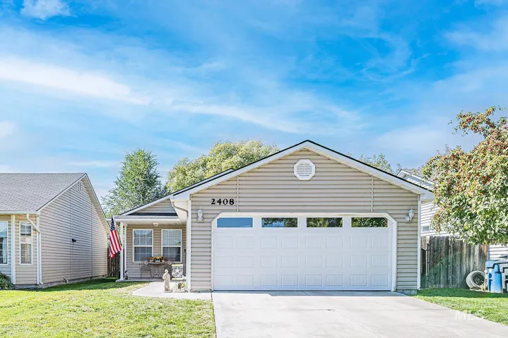 Single story home with concrete driveway and an attached garage