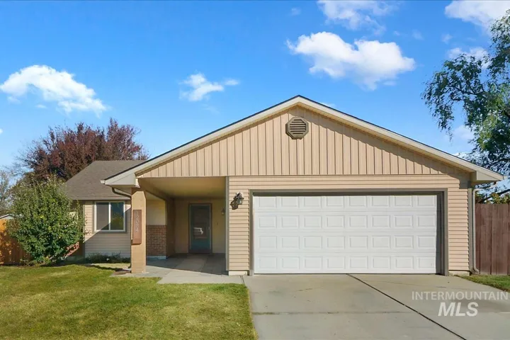 Single-story residence featuring light-toned vertical and horizontal siding, a covered entryway, an attached two-car garage, and a concrete driveway