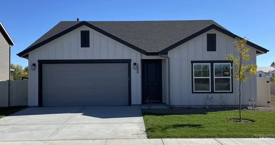 Modern farmhouse style home featuring roof with shingles, board and batten siding, an attached garage, and concrete driveway