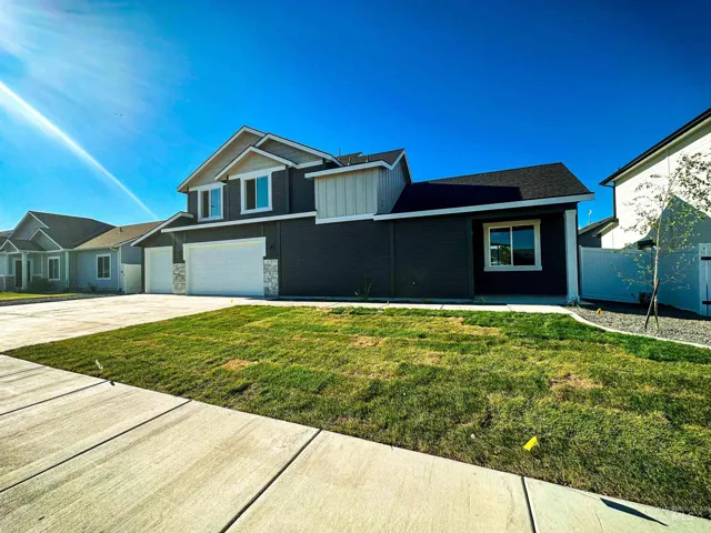 Contemporary two-story residence featuring dark siding with light gray architectural accents.