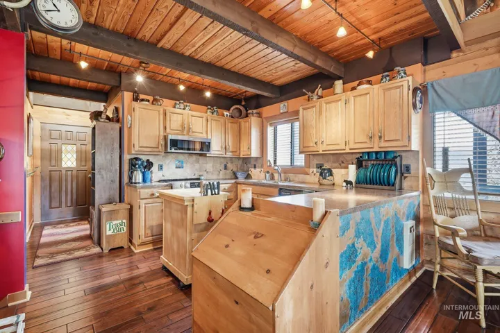 Kitchen featuring wood-finish flooring, wood cabinetry, a built-in microwave, and track lighting