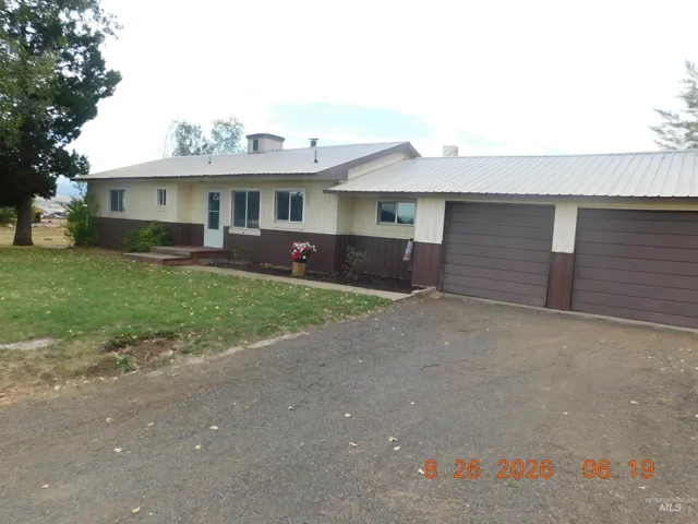 Two-tone exterior with metal roofing, multiple windows, and an attached two-car garage