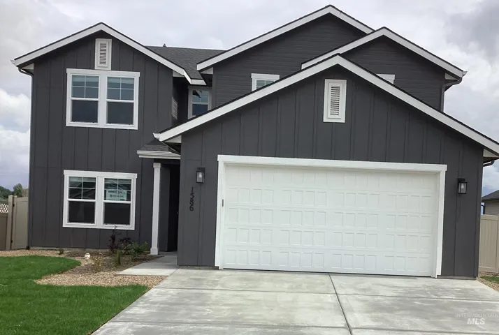 View of front of house with board and batten siding, driveway, and a garage