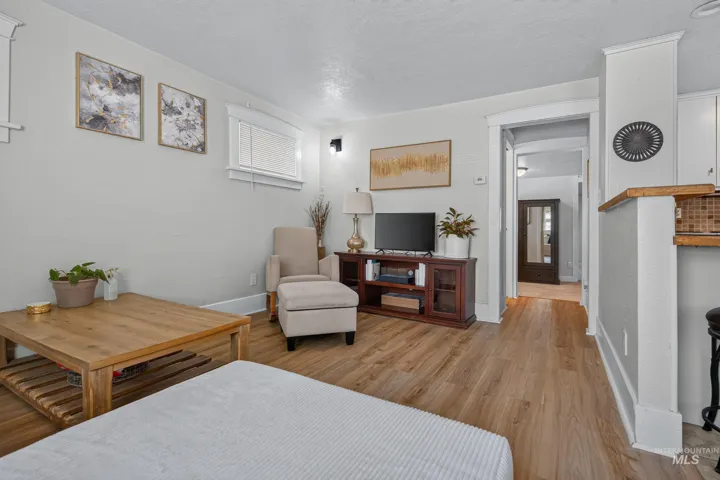Living area featuring wood-finish flooring, light grey walls, and white trim