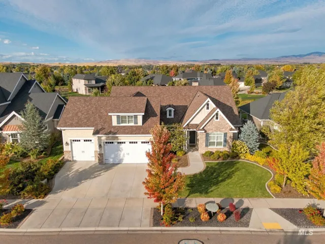 Traditional-style residence featuring a stone and siding exterior, multi-gabled roofline, and attached three-car garage