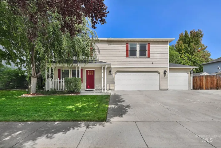 Two-story residence with light-colored siding, a covered front porch, and a red entry door