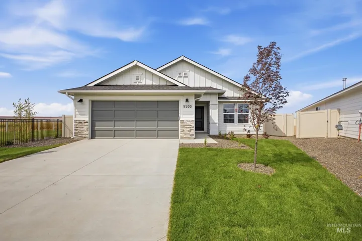 Modern farmhouse exterior featuring vertical siding, stone accents, and a panel-style garage door