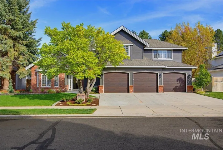 Brick and siding exterior with a three-car garage and concrete driveway
