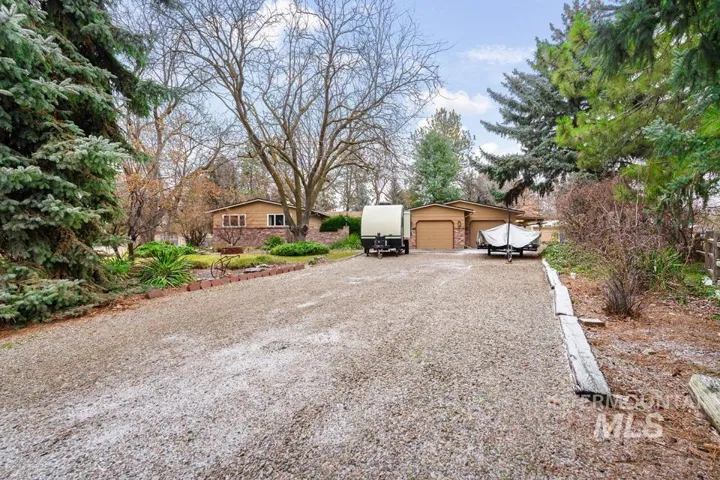 View of front of house featuring driveway, a detached garage, and an outdoor structure