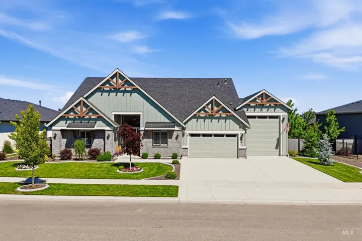 Craftsman-style exterior featuring vertical siding, masonry lower-level veneer, timber-accented gables, and a three-car garage