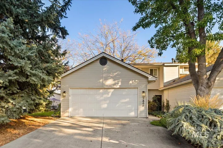 Single-family residence featuring a two-car garage, concrete driveway, and mature landscaping