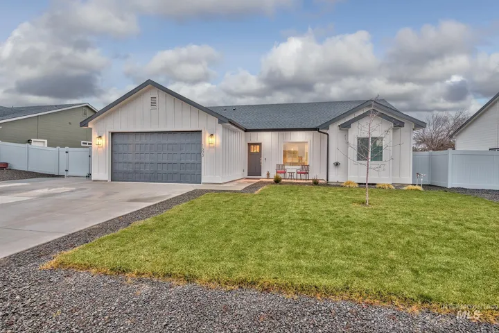 View of front of home with board and batten siding, driveway, a shingled roof, and an attached garage