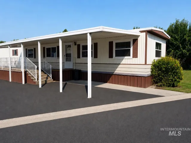 Single-story residence featuring light-colored siding with contrasting brown trim and shutters