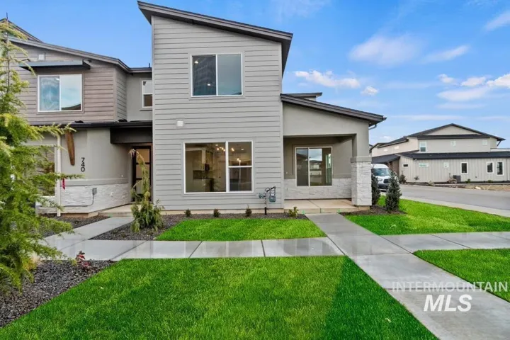 Contemporary house with a front lawn, stucco siding, and stone siding