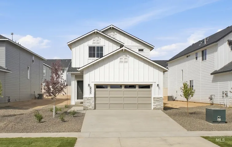 Two-story exterior with board and batten siding, stone facade accents, and an attached two-car garage