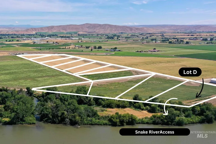 Aerial view of sparsely populated area with property parcel outlined and mountains
