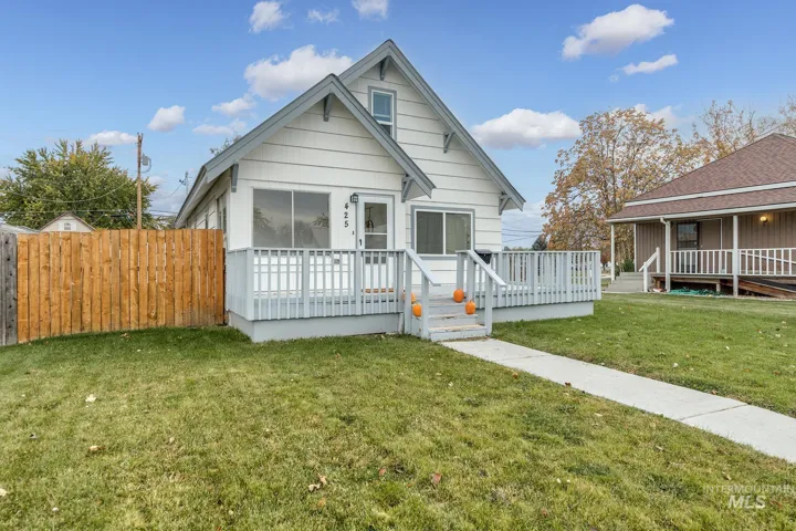 View of front of house featuring a front lawn and a wooden deck