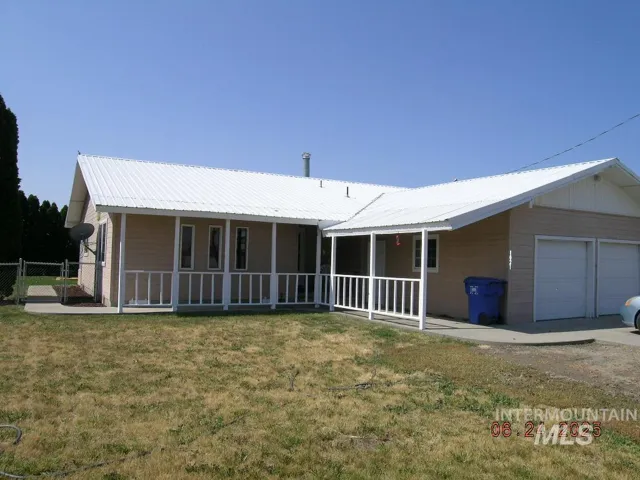 View of front of house featuring covered porch and a metal roof