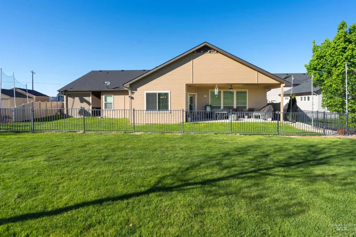 Expansive green lawn with a black metal perimeter fence