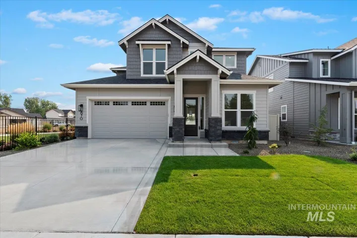 Craftsman inspired home with driveway, stone siding, and a shingled roof