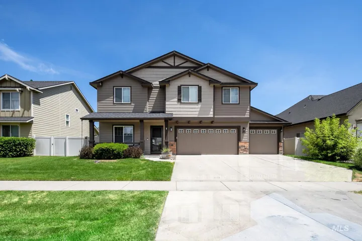 Two-story residence featuring a covered front porch with dark columns, a combination of horizontal siding and stone accents, and a three-car garage with carriage-style doors