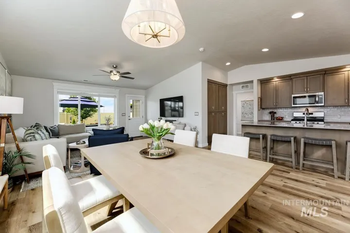 Integrated dining space with a contemporary chandelier and wood-finish flooring