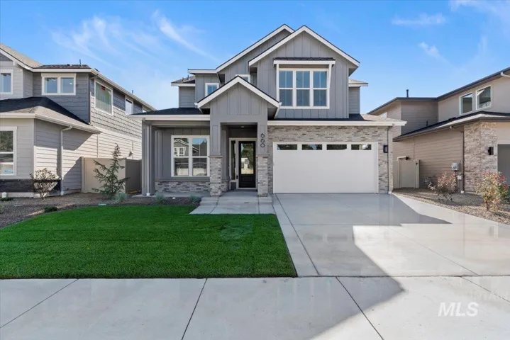 View of front of property featuring board and batten siding, concrete driveway, an attached garage, and brick siding. Photo Similar