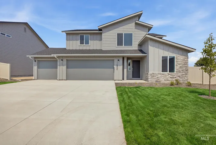 Modern exterior with mixed siding, stone accents, a multi-car garage, and a concrete driveway