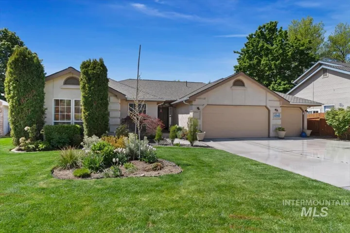 Stucco exterior with a pitched roofline, an attached two-car garage, and a concrete driveway