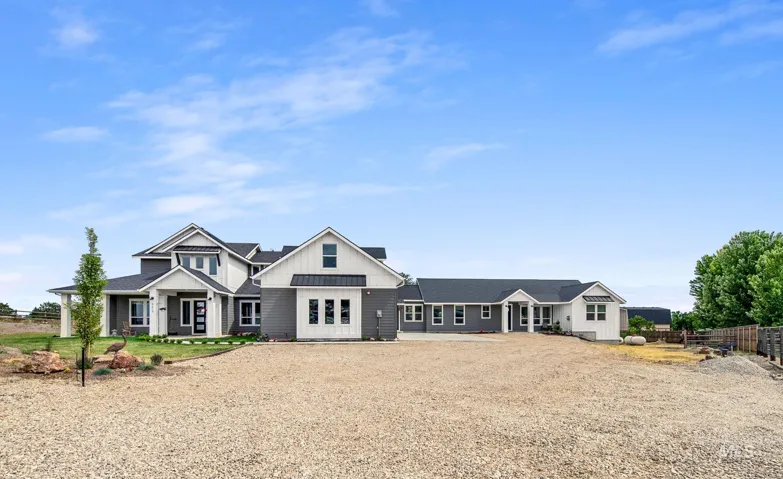 Farmhouse-style residence featuring a gray and white exterior with dark-framed windows