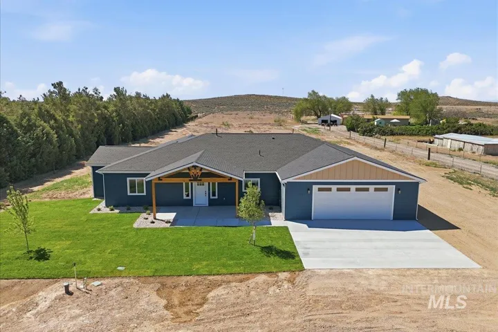 Contemporary ranch-style residence featuring a dark blue facade with tan gable accents