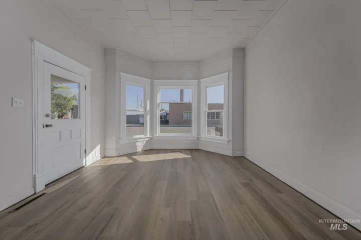 Entryway with crown molding and wood finished floors