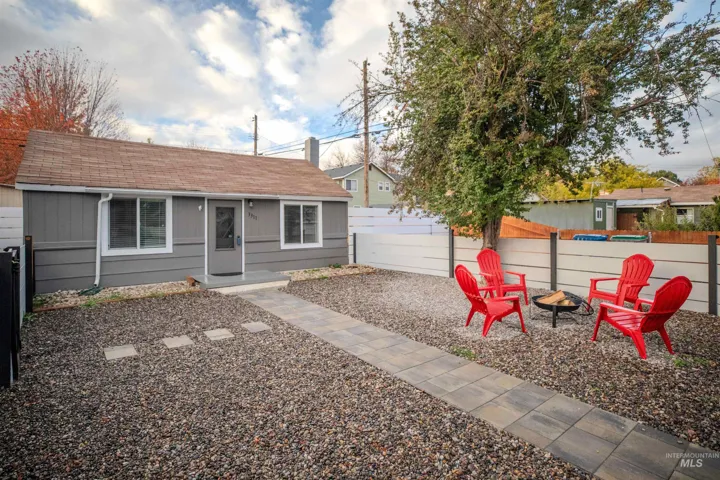 View of front of property with a fire pit, roof with shingles, and a fenced front yard