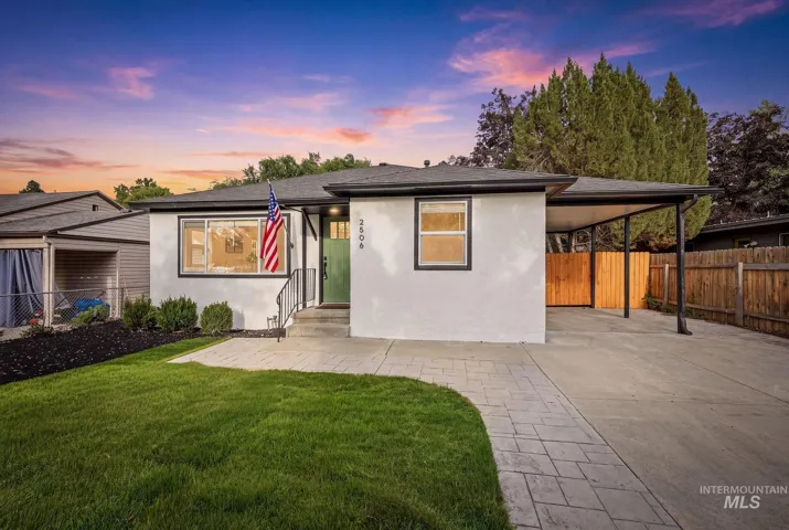White stucco exterior with black trim and green entry door