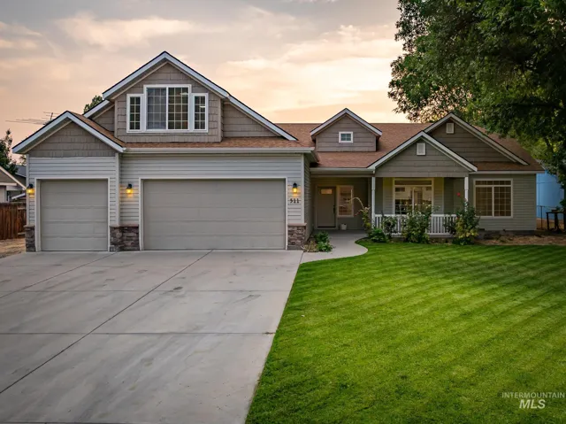 Two-car garage, covered entry porch, front lawn, and concrete driveway
