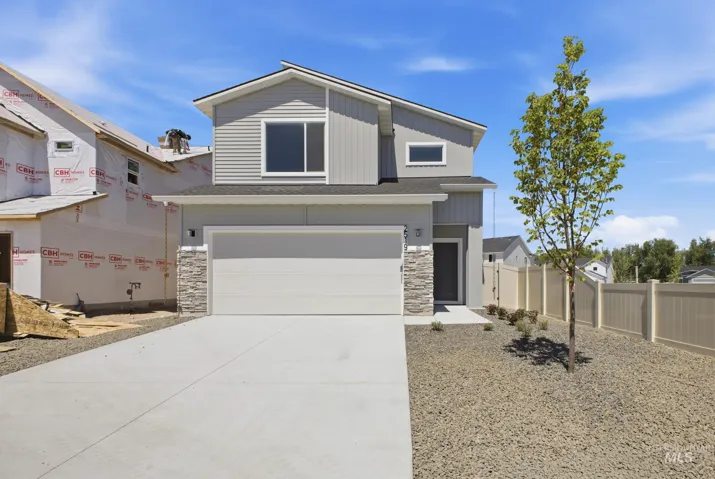 Contemporary two-story residence featuring light gray siding and stone facade accents