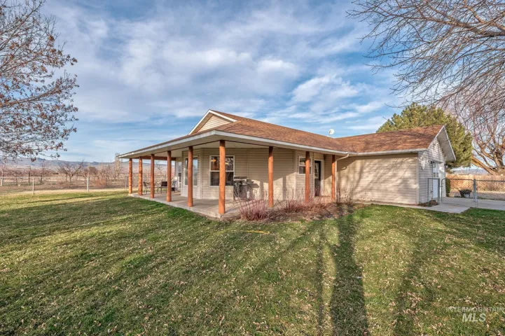 Rear view of property with a large porch, a shingled roof, and a gate