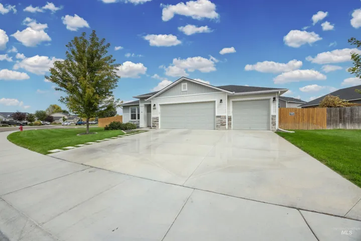 Contemporary ranch-style residence featuring a two-car garage, stone and siding exterior, and a concrete driveway