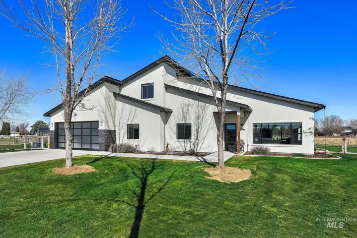 View of front of property with stucco siding, an attached garage, and driveway