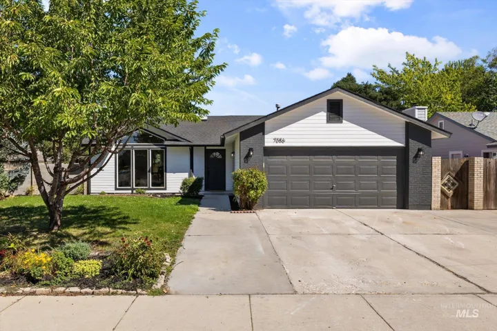 Ranch-style home with brick siding, a front lawn, an attached garage, and driveway