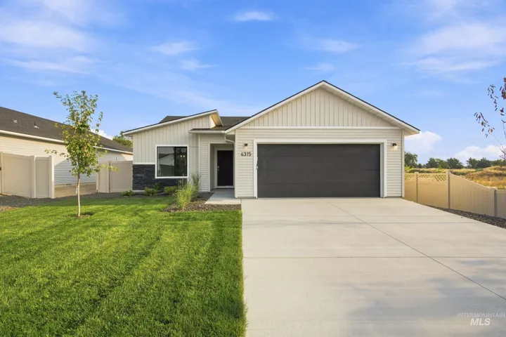 Modern single-story home featuring a clean facade with vertical siding, a covered front entry with sconce lighting, and a spacious two-car garage with a dark finish