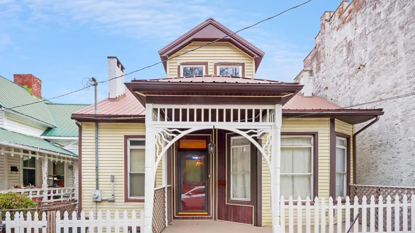 Amy Houston Team Charming Front Elevation Featuring a Covered Porch with Decorative Trim Picket Fence and Classic Architectural Details a Welcoming Entry That Highlights the Homes Character and Curb Appeal Northern Kentucky Real Estate